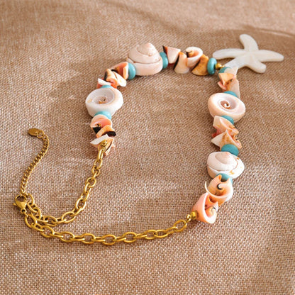 Shell bracelet with a gold chain on a textured beige surface