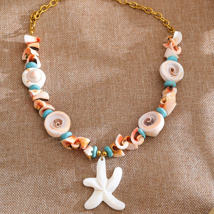 Necklace with shell beads and a starfish charm on a textured brown background