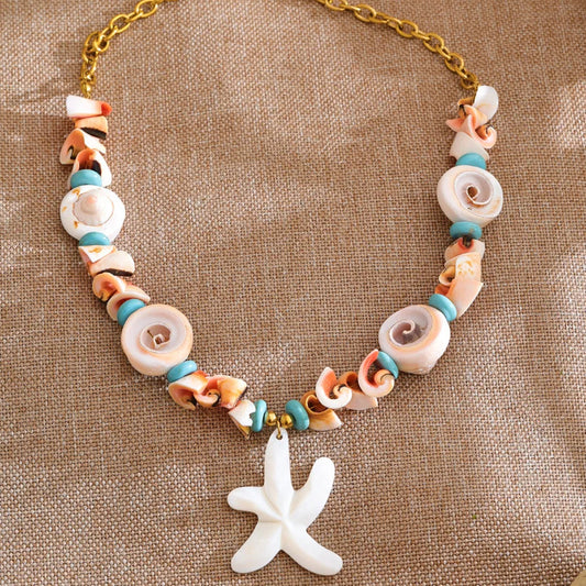 Necklace with shell beads and a starfish charm on a textured brown background