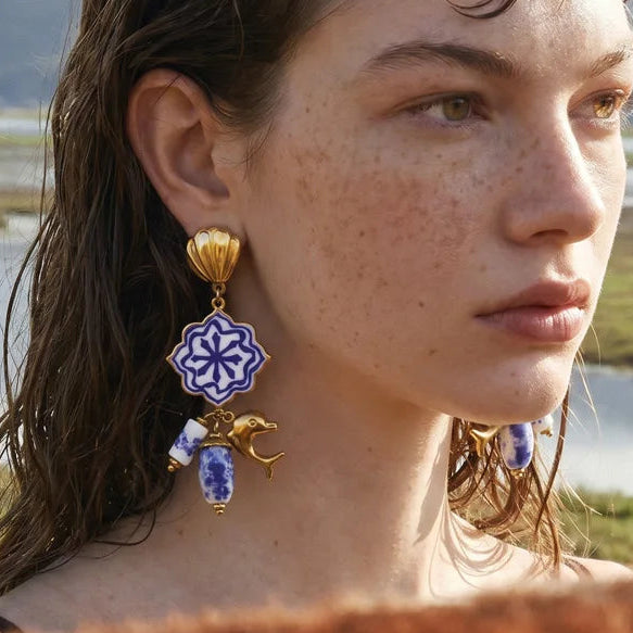 Woman wearing decorative earrings with a scenic background