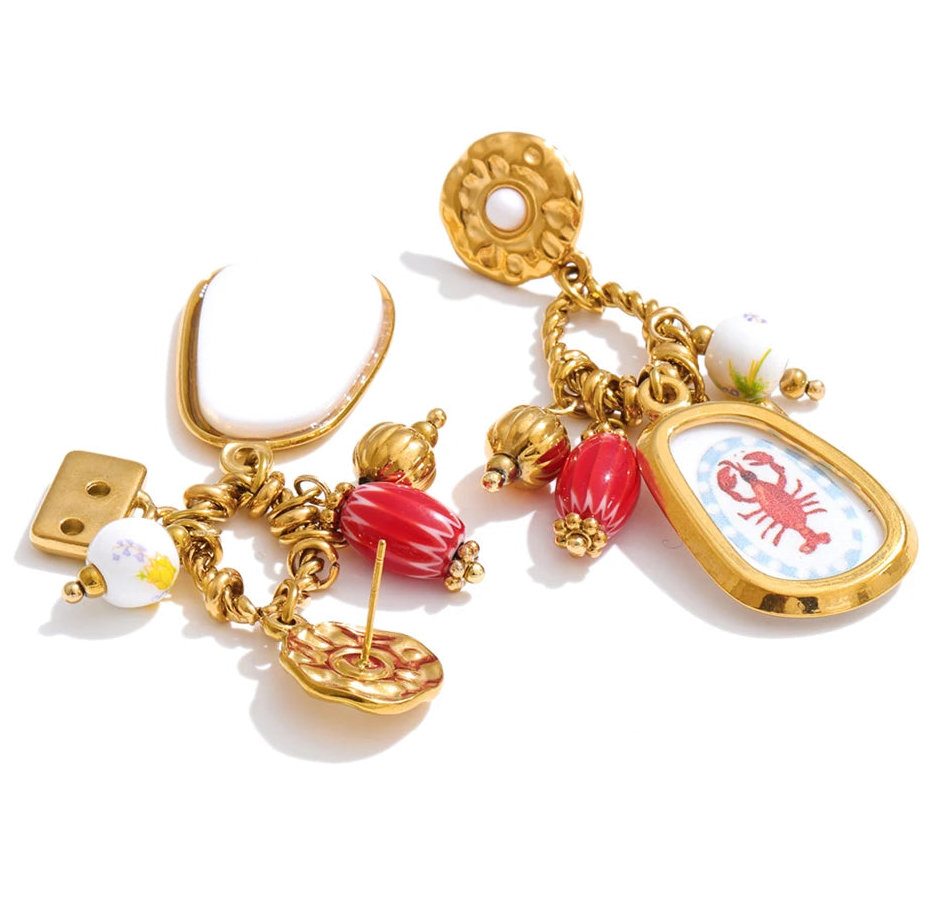 Gold earrings with colorful charms on a white background
