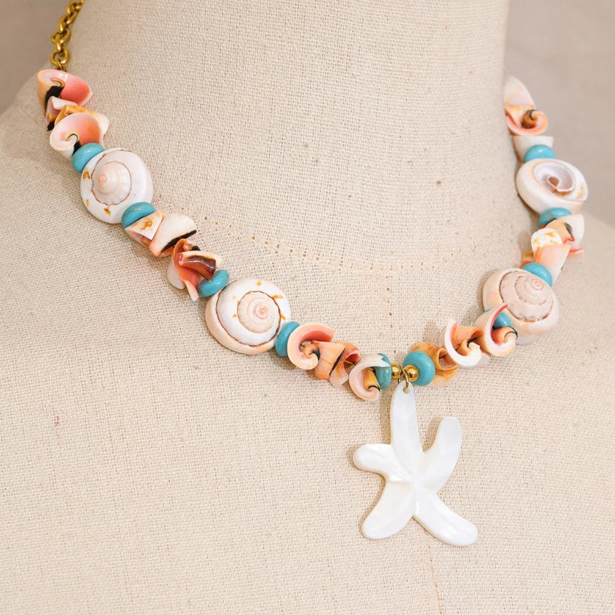 Necklace with shell beads and a starfish charm on a beige background