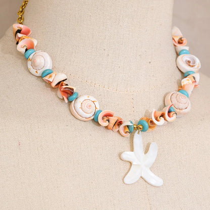 Necklace with shell beads and a starfish charm on a beige background