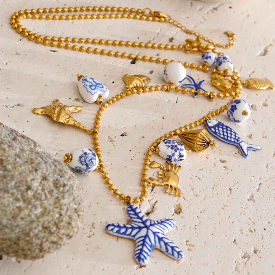 Necklace with blue and white ceramic charms on a textured surface