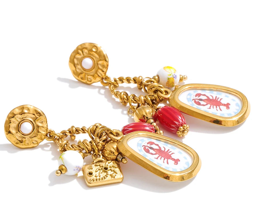 Gold charm bracelet with lobster-themed charms on a white background
