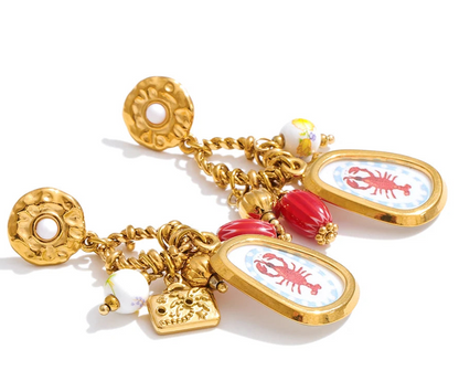 Gold charm bracelet with lobster-themed charms on a white background
